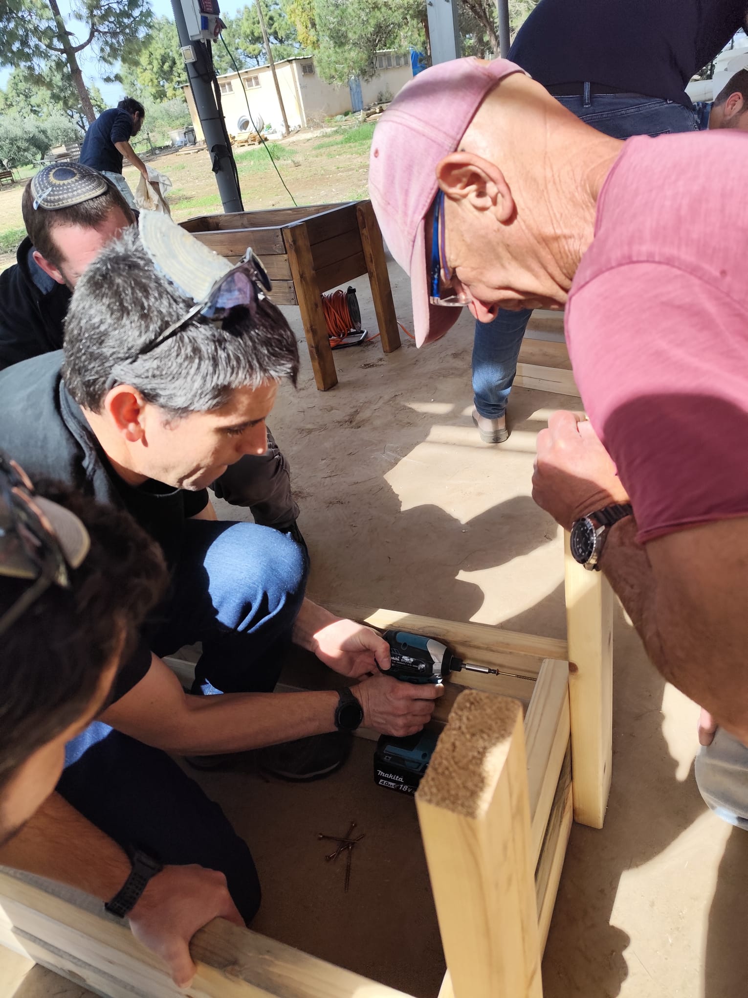 Participant drilling into wood at the outdoor workshop